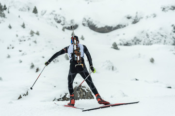 Winter sports. A participant in a biathlon competition, in a winter season in Spain, in a snowy landscape.