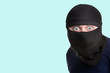man in a balaclava on a blue background, concept of catching a criminal at a crime scene