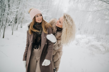 Photo of two blonde women on walk in winter forest