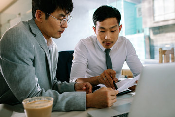 Two business people working together in a coffee shop