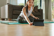 © Jacob Lund - Woman using digital tablet while exercising at home