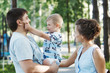 © olgasparrow - Young happy family: father, mother and blond boy walking in the park.