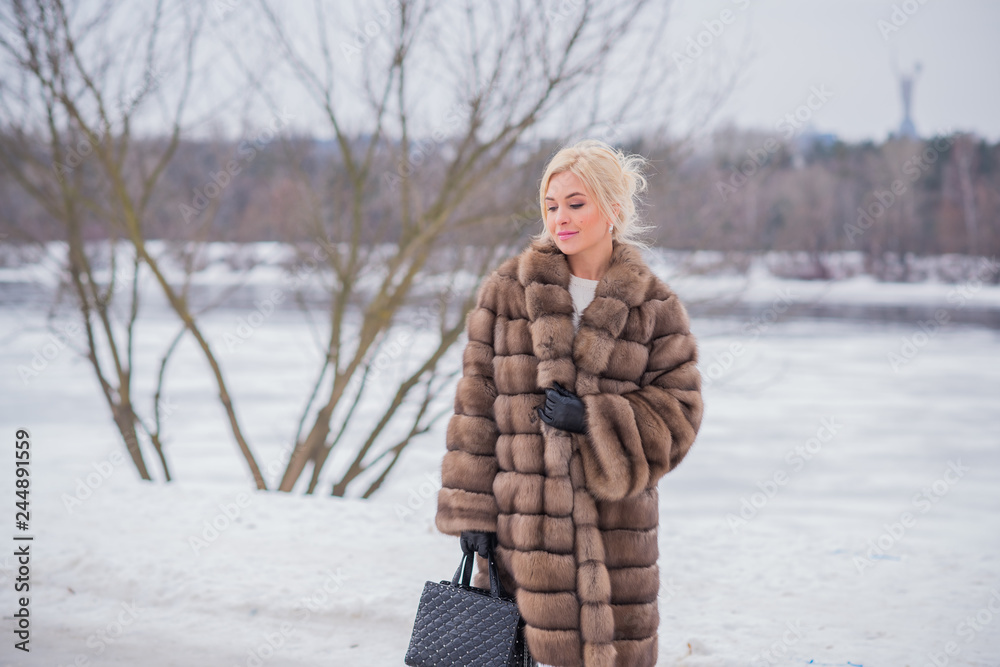 Nice elegant lady in fur coat at nature, autumn - winter season time ...