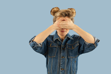 Young beautiful strongly emotional girl shows different gestures on an isolated blue background. Concept of human emotions