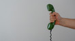 © gabort - hand holding green telephone receiver with copy space, banner size