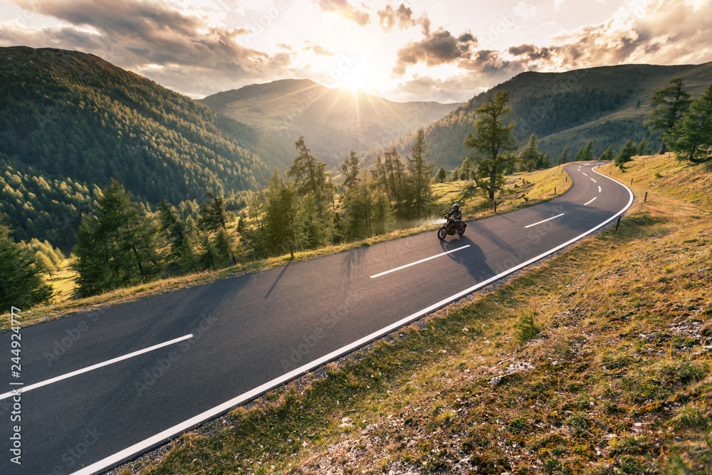 Motorcycle driver riding in Alpine road Stock Photo | Adobe Stock