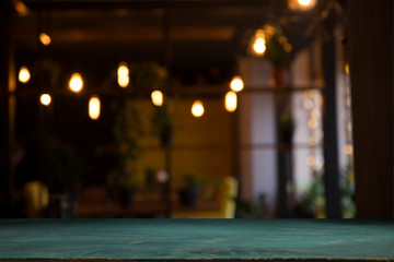 image of wooden table in front of abstract blurred background of resturant lights