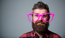 Nerd Concept. Hipster Looking Through Of Giant Pink Eyeglasses. Man Beard And Mustache Face Wear Funny Big Eyeglasses. Life In Pink Color. Naivety Man. Naivety And Simplicity. Adult But Still Naivety