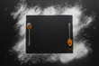 © gphotomuc - a white powder frame in sugar or flour optic with two spice filled spoons on a black slate stone background