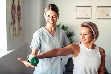 Wall Mural - A Modern rehabilitation physiotherapy worker with woman client