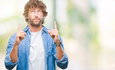 Sticker - Handsome hispanic model man over isolated background amazed and surprised looking up and pointing with fingers and raised arms.