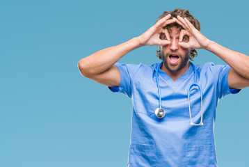 Canvas Print - Handsome hispanic surgeon doctor man over isolated background doing ok gesture like binoculars sticking tongue out, eyes looking through fingers. Crazy expression.