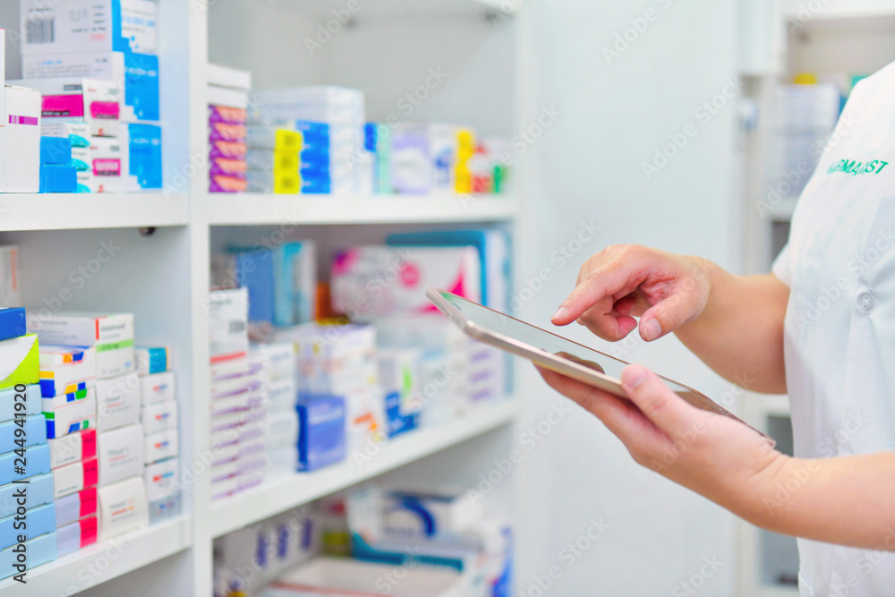 Pharmacist holding computer tablet Using for filling prescription in pharmacy drugstore  - obrazy, fototapety, plakaty 