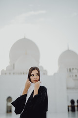 Wall Mural - Beautiful young woman in Arabic clothes at Sheikh Zayed Grand Mosque in Abu Dhabi.