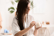 © Pixel-Shot - Young woman applying cream on beautiful long hair in bathroom