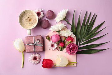 Composition with beautiful flowers, gift box and cup of coffee on color background