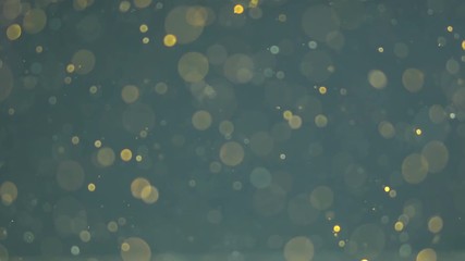 Abstract gold particles blue background. Gold bokeh lights. Blinking particles moving. Light shine bokeh.