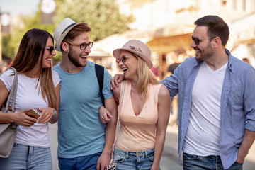 Wall Mural - Happy smiling young friends walking outdoors