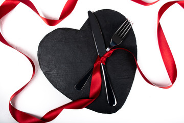 Heart shaped black plate dinner or lunch table setting for valentine day romantic celebration