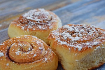 Wall Mural - Delicious cinnamon rolls on wooden background.Fresh pastry.