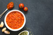 Homemade traditional Italian marinara or pomodoro tomato sauce made of fresh tomato, garlic, dried oregano and salt, photographed overhead on slate with natural light (Selective Focus on the sauce)