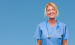 Middle age blonde nurse surgeon doctor woman over isolated background with serious expression on face. Simple and natural looking at the camera.