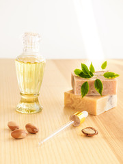 Wall Mural - Bottle with cosmetic oil argan nuts. Cosmetic means. Food product. Jar with argan oil and handmade soap on the wooden background