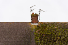 Cloudy Day View Traditional British House Roof With Chimney Half Full With Moss And Half Cleaned