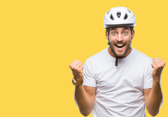 Wall Mural - Young handsome man wearing cyclist safety helmet over isolated background celebrating surprised and amazed for success with arms raised and open eyes. Winner concept.