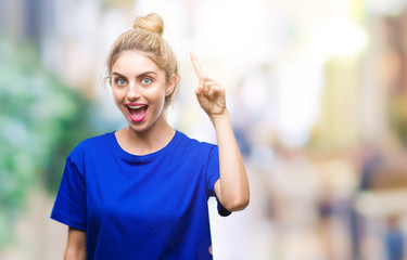 Sticker - Young beautiful blonde and blue eyes woman wearing blue t-shirt over isolated background pointing finger up with successful idea. Exited and happy. Number one.