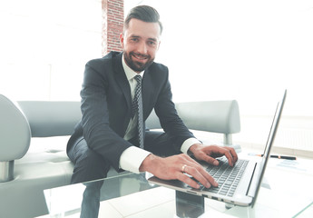 Successful man working on laptop in modern office