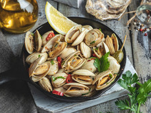 Cooked Seafood Clams In The Iron Pan Portion With Lemon And Seasoning