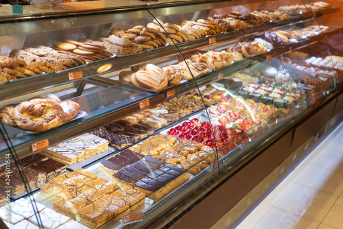 Cuadros en Lienzo Different types of delicious cakes in pastry shop showcase .