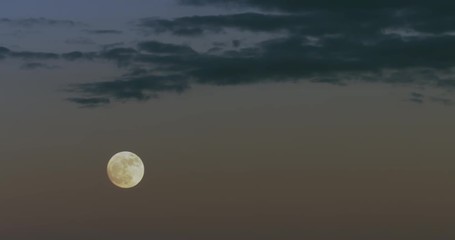 Wall Mural - Nice shot of a full moon at dusk with sunset sky and some nice clouds in the sky