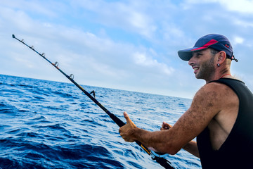 The brutal young man on sea fishing. Trolling.