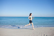 © Ulia Koltyrina - Young woman in shorts running on the beach