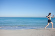 © Ulia Koltyrina - Young woman in shorts running on the beach