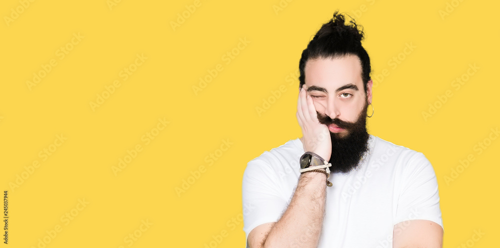 Young hipster man with long hair and beard wearing casual white t-shirt thinking looking tired and bored with depression problems with crossed arms. - obrazy, fototapety, plakaty 