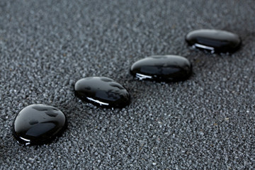 Stones with drops of water on a black background