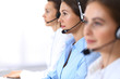© rogerphoto - Call center. Group of operators at work. Focus at beautiful business woman in headset