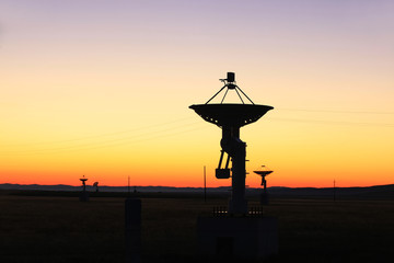 The silhouette of a radio telescope