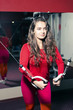 © Olek - Young beautiful athletic girl trains on the simulator in the gym. sporty woman in red leggings doing exercise