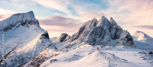 Fototapeta na szkło Panorama alpinista stojący na szczycie ośnieżonych gór