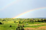 Fototapeta Tęcza - Double rainbow over the valley near the river after a rain at beautiful summer day