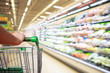 © Kwangmoozaa - woman hand hold supermarket shopping cart with abstract blur organic fresh fruits and vegetable on shelves in grocery store