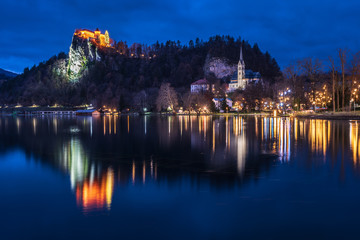 Night on Lake Bled. Christmas atmosphere and lights. Castle and Church of the Annunciation