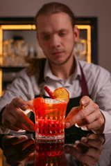 Wall Mural - Professional bartender prepairing orange cocktail 