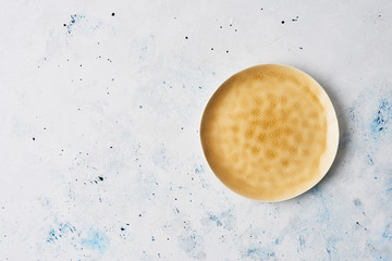 Wall Mural - modern pottery. yellow dinner plate, empty ceramic plate with abstract yellow texture on abstract wh