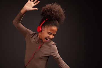 Lovely girl listening to music in red earphones