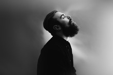 Black And White Photo Portrait Of A Stylish Man In Profile With A Beard Dressed In The Black Shirt In The Fog